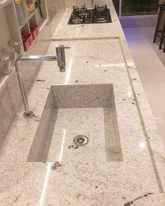 a kitchen counter top with a sink and faucet in the middle of it