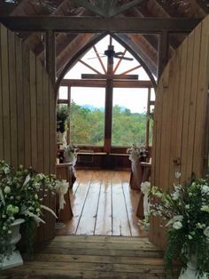 the inside of a wooden church with flowers in vases