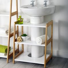 a white sink sitting on top of a wooden shelf