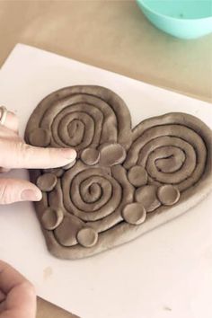 someone is making a heart shaped cookie with chocolate icing