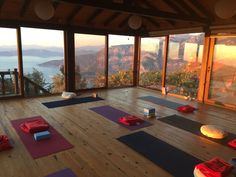 there are many yoga mats on the floor in front of large windows with mountain view