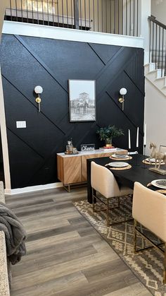 the dining room table is set with place settings for four people, and there's also a staircase leading up to the second floor