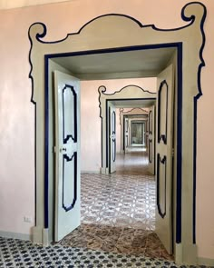 an open door leading into a hallway with black and white designs on the walls