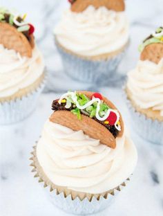 several cupcakes with frosting and toppings on them