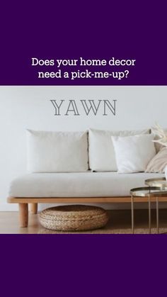 a white couch sitting next to a table on top of a hard wood floor covered in pillows