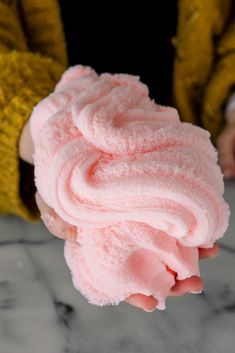 someone holding up a pink ice cream in their hand