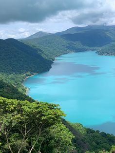 the blue water is surrounded by trees and mountains