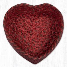 a knitted heart shaped pillow sitting on top of a white table