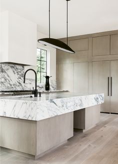 a kitchen with marble counter tops and an island