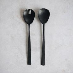 two black spoons sitting next to each other