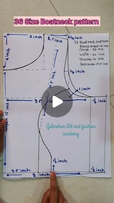 someone is pointing at a pattern on a piece of paper