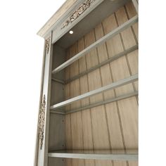 an empty bookcase with wooden shelves and decorative carvings