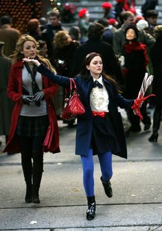 two women are walking down the street with their hands in the air and one is holding something