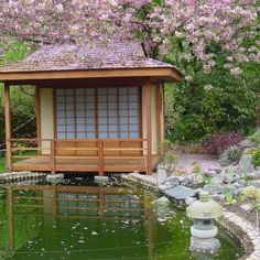 a small wooden gazebo sitting next to a pond