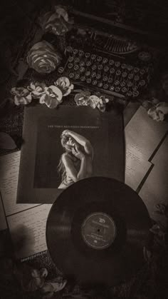 an old fashioned typewriter, record player and other items on a table in black and white