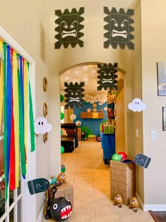 a hallway decorated for halloween with decorations on the ceiling and paper monsters hanging from the ceiling