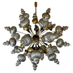 a chandelier made out of silver and gold metal shells on a white background