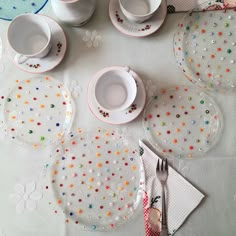 a table topped with plates and cups filled with confetti