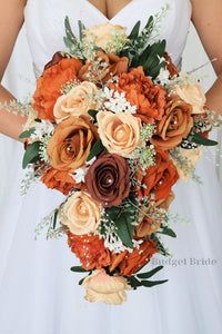 a bridal holding a bouquet of orange and brown flowers on her wedding day,