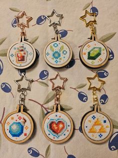 six cross stitch keychains with different designs on them