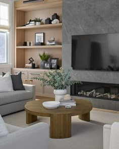 a living room filled with furniture and a flat screen tv mounted on the wall above a fireplace