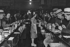 a group of people sitting at long tables in a restaurant