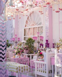 a room filled with lots of pink furniture and flowers on top of it's tables