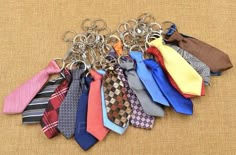 a bunch of ties that are sitting on a table with one keychain in the middle