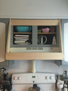 an open cabinet above the stove in a kitchen