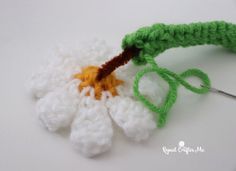 a crocheted flower is being worked on