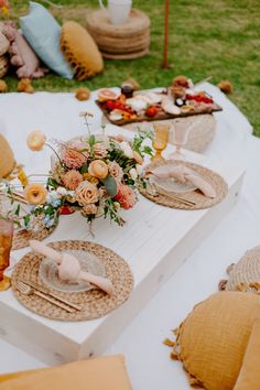 the table is set with plates and place settings for an outdoor picnic party or brunch