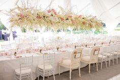 the tables are set with white linens and pink floral centerpieces on them