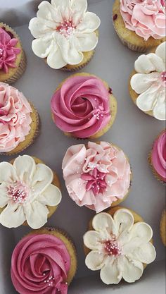 cupcakes with pink and white frosting in a box