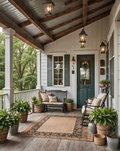 a porch with chairs and potted plants on the front steps, lights hanging from the ceiling