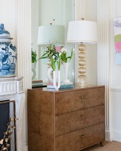 a dresser with two vases and flowers on it