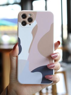 a woman holding up her phone case with an abstract design on the front and back