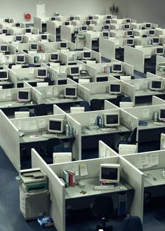 rows of cubicles with computers and telephones in them