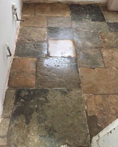 a tile floor that has been cleaned and is in the process of being replaced by someone