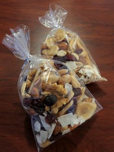 two bags filled with nuts and raisins on top of a wooden table