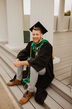 a man sitting on steps wearing a graduation cap and gown