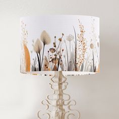 a lamp that is on top of a table with a flower design on the lampshade