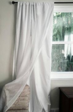 a white curtain hanging from the side of a window