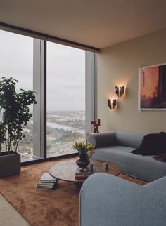 a living room filled with furniture and a large window next to a wall mounted painting