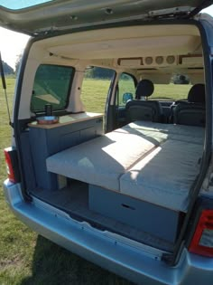 the back end of a van with an open trunk and mattress on it's side