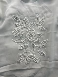 an embroidered white shirt with flowers on it