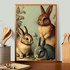 two rabbits sitting next to each other in front of a painting on a table with utensils