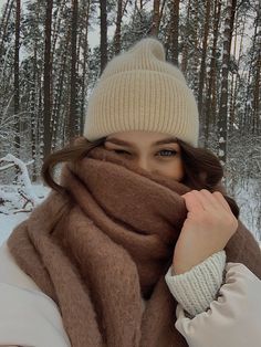 a woman wearing a hat and scarf in the snow