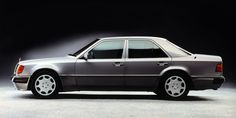 a silver mercedes benz parked in front of a black background