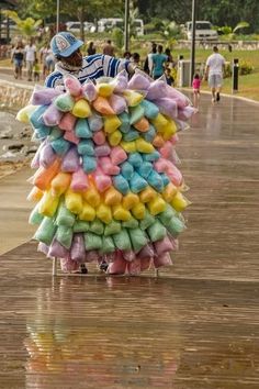 a person is walking down the street with a large pile of marshmallows