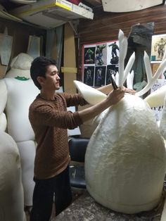 a man is working on an object made out of paper machs in a shop